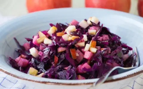 Schüssel mit leckerem rotkohl salat und Apfelstücken. Ein Klassiker, der immer schmeckt.