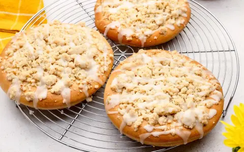 Drei runde Streusel Taler mit Zuckerguss auf einem Kuchengitter, bereit zum Genießen.