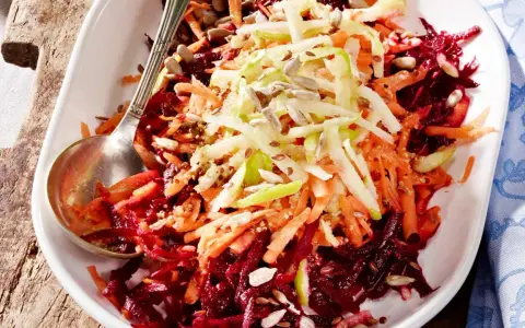Bunter Rote Bete Salat mit geraspelten Karotten und Apfel, bestreut mit Sonnenblumenkernen und Leinsamen.
