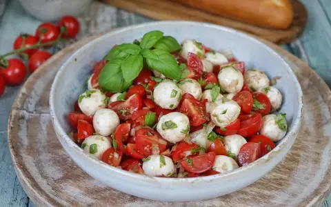 Tomate Mozzarella Salat mit frischem Basilikum und einem leichten Dressing. Perfekt als leichte Mahlzeit.