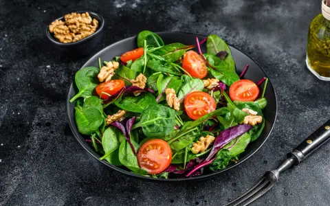 Frischer Mangoldsalat mit Kirschtomaten und Walnüssen, bereit zum Genießen.