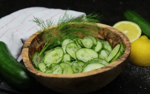 Frischer Gurkensalat im Holzschälchen, garniert mit Dill. Ein einfaches gurkensalat rezept für den Sommer.