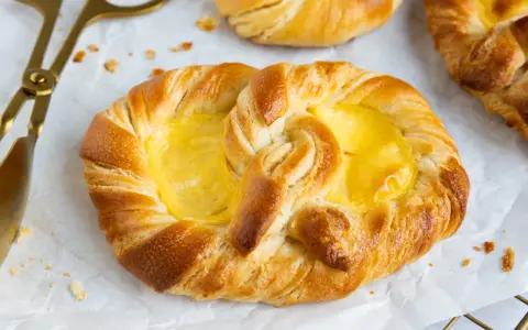 Goldene puddingbrezeln, frisch gebacken, warten auf das puddingbrezel rezept. Daneben liegt eine goldene Zange.