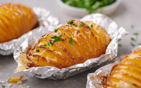 Leckere Hasselback-Kartoffeln, bestreut mit Käse und Petersilie. Ein einfaches Gericht aus der Kategorie Kartoffel Rezepte.
