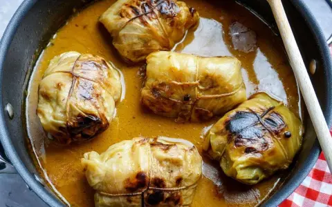 Fünf Kohlrouladen im Topf, bereit für ein köstliches Kohlrouladen Rezept.