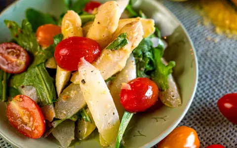 Klassischer Spargelsalat mit Kirschtomaten und frischen Kräutern, ein leichtes und gesundes Gericht.