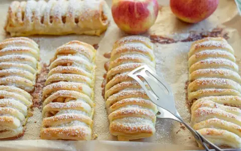 Frisch gebackene Apfeltaschen, bestäubt mit Puderzucker. Ein köstliches Apfeltaschen Rezept, das zum Genießen einlädt.