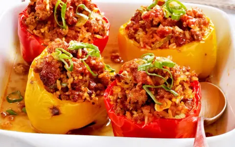 Gefüllte Paprika mit Hackfleisch und Reis, garniert mit Frühlingszwiebeln. Ein Klassiker der Paprika Rezepte.