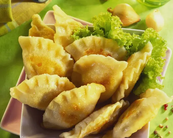 Goldbraune Pierogi, frisch zubereitet nach einem tollen Pierogi Rezept, serviert mit Salat.