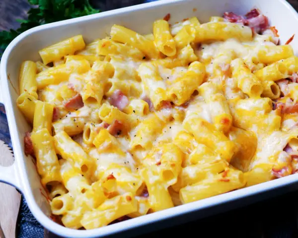 Herzhaftes Nudel Schinken Gratin mit geschmolzenem Käse, frisch aus dem Ofen. Perfekt für kalte Tage!
