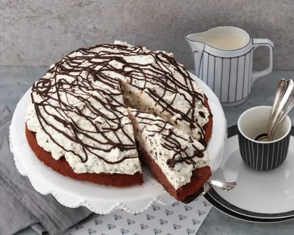 Eine köstliche Schoko Stracciatella Torte mit viel Sahne und Schokoladenraspeln, bereit zum Genießen.