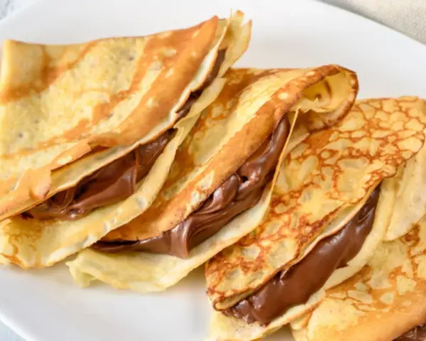 Drei gefaltete Crêpes mit Schokoladencreme, ein einfaches und leckeres Crepes Rezept für jeden Anlass.
