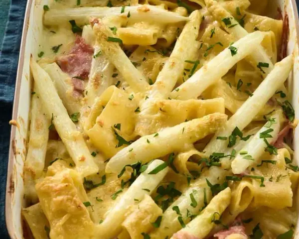 Ein cremiger Spargel Nudel Auflauf mit Schinken und frischer Petersilie, goldbraun überbacken.