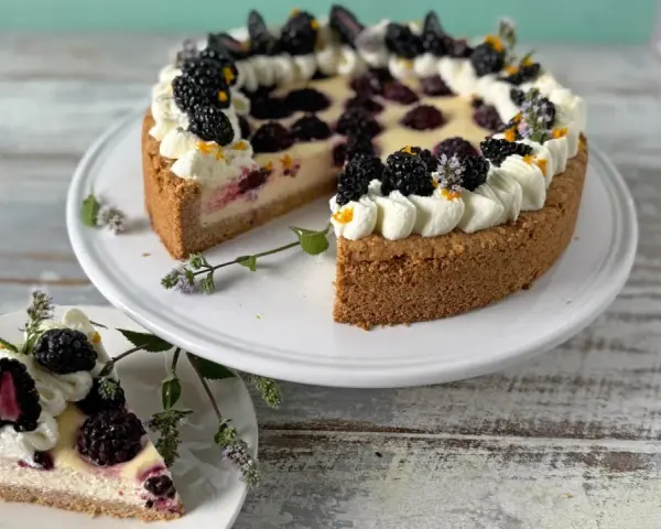 Eine köstliche Brombeertorte, verziert mit Sahnetuffs und frischen Brombeeren. Dieses Brombeertorte Rezept sieht zum Anbeißen aus!