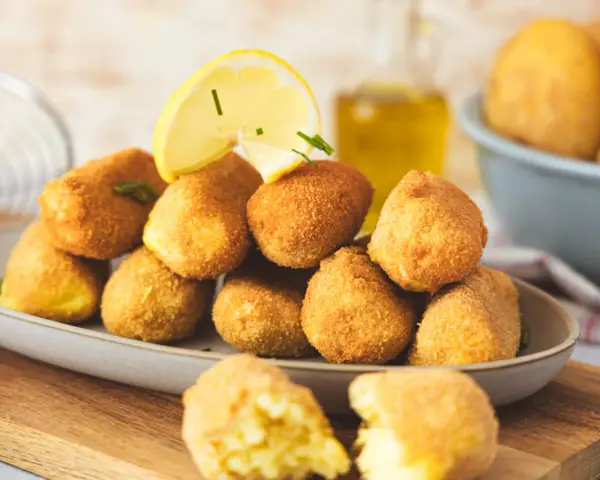 Goldbraune, knusprige Kroketten, frisch zubereitet, mit Zitrone und Kräutern garniert. Perfekt zum Selbermachen!