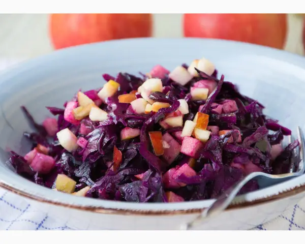 Schüssel mit leckerem rotkohl salat und Apfelstücken. Ein Klassiker, der immer schmeckt.