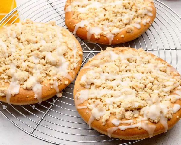 Drei runde Streusel Taler mit Zuckerguss auf einem Kuchengitter, bereit zum Genießen.