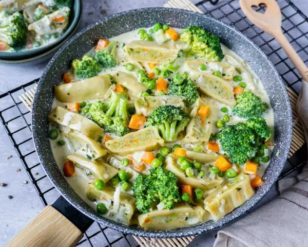 Herzhafte Maultaschen in cremiger Soße mit Brokkoli, Erbsen und Karotten. Ein leckeres Gericht, das Lust auf mehr Maultaschen Rezepte macht.