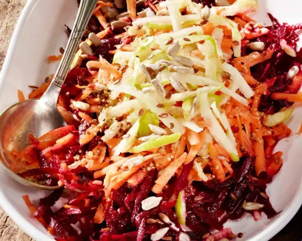Bunter Rote Bete Salat mit geraspelten Karotten und Apfel, bestreut mit Sonnenblumenkernen und Leinsamen.