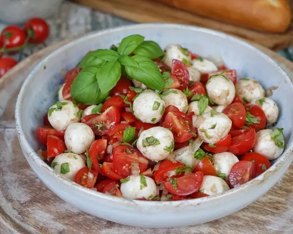 Tomate Mozzarella Salat mit frischem Basilikum und einem leichten Dressing. Perfekt als leichte Mahlzeit.