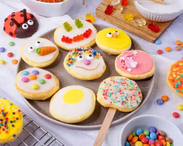 Bunte mini Amerikaner mit lustigen Gesichtern, Marienkäfer und Karotte. Ein süßer Genuss für Groß und Klein.