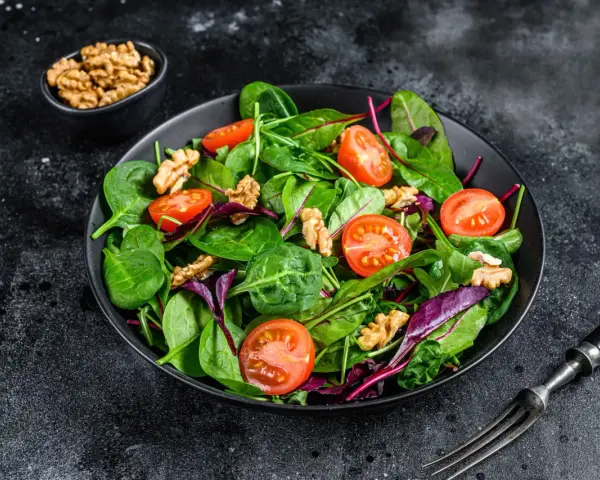 Frischer Mangoldsalat mit Kirschtomaten und Walnüssen, bereit zum Genießen.