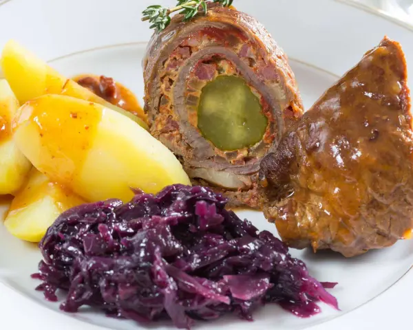 Rinderrouladen mit Rotkohl und Kartoffeln, ein deftiges Gericht, das nach Hausmannskost schmeckt.