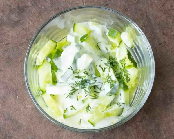 Erfrischender Gurkensalat mit Joghurt und Dill in einer Glasschüssel, bereit zum Genießen.