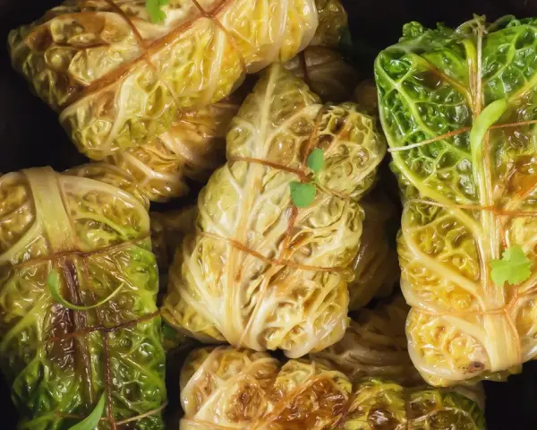 Gefüllte Kohlrouladen, ein Klassiker der wirsing rezepte, sind liebevoll mit Schnur gebunden und bereit zum Genuss.