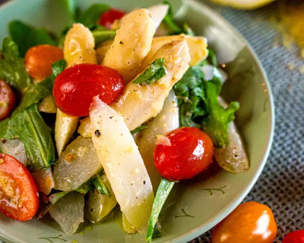 Klassischer Spargelsalat mit Kirschtomaten und frischen Kräutern, ein leichtes und gesundes Gericht.