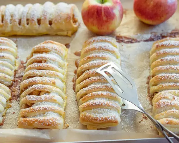 Frisch gebackene Apfeltaschen, bestäubt mit Puderzucker. Ein köstliches Apfeltaschen Rezept, das zum Genießen einlädt.