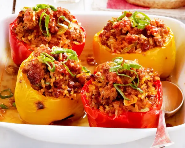 Gefüllte Paprika mit Hackfleisch und Reis, garniert mit Frühlingszwiebeln. Ein Klassiker der Paprika Rezepte.