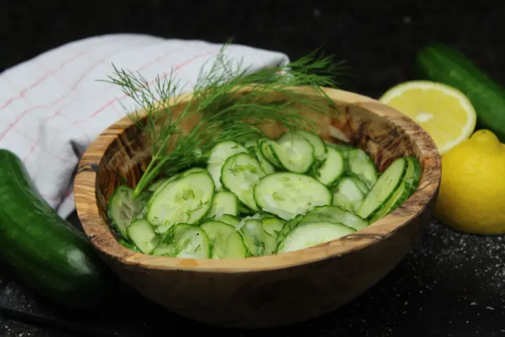 Frischer Gurkensalat im Holzschälchen, garniert mit Dill. Ein einfaches gurkensalat rezept für den Sommer.
