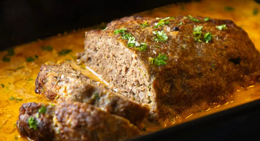Saftiger Hackbraten mit cremiger Sauce, garniert mit Petersilie. Ein köstliches Hackbraten Rezept, das jeden begeistert.