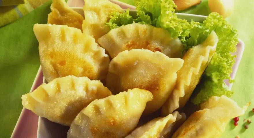 Goldbraune Pierogi, frisch zubereitet nach einem tollen Pierogi Rezept, serviert mit Salat.