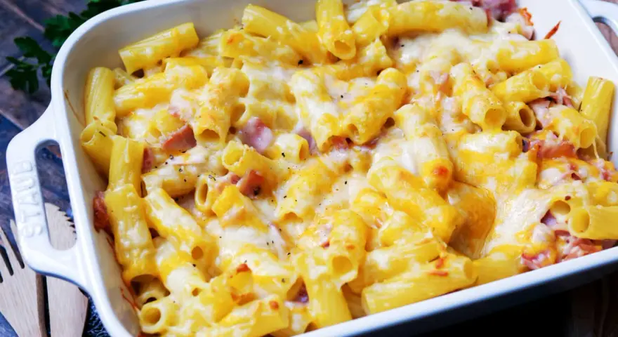 Herzhaftes Nudel Schinken Gratin mit geschmolzenem Käse, frisch aus dem Ofen. Perfekt für kalte Tage!