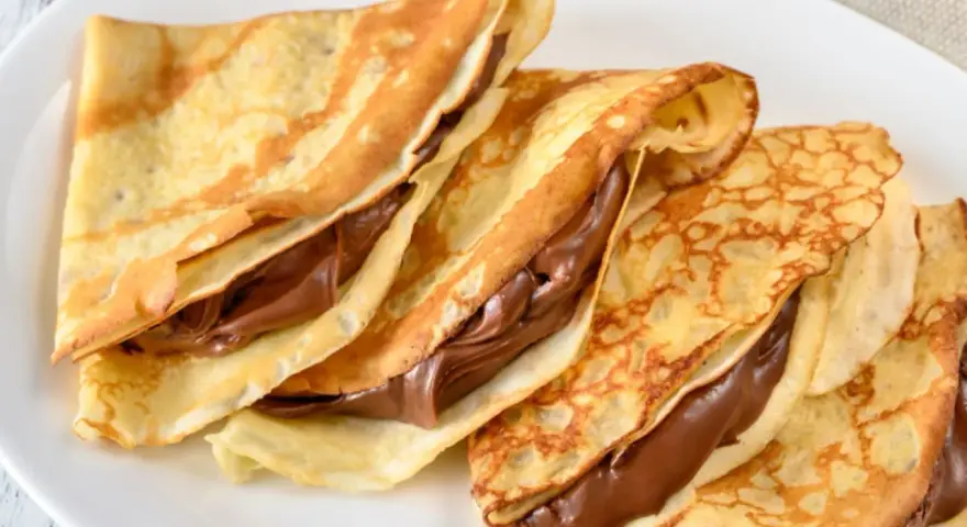 Drei gefaltete Crêpes mit Schokoladencreme, ein einfaches und leckeres Crepes Rezept für jeden Anlass.