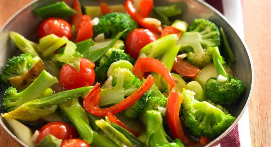 Buntes Gemüse aus Brokkoli, Tomaten und Paprika in einer Pfanne, perfekt für ein schnelles und gesundes Rezept.