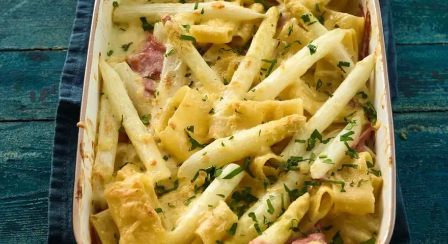Ein cremiger Spargel Nudel Auflauf mit Schinken und frischer Petersilie, goldbraun überbacken.
