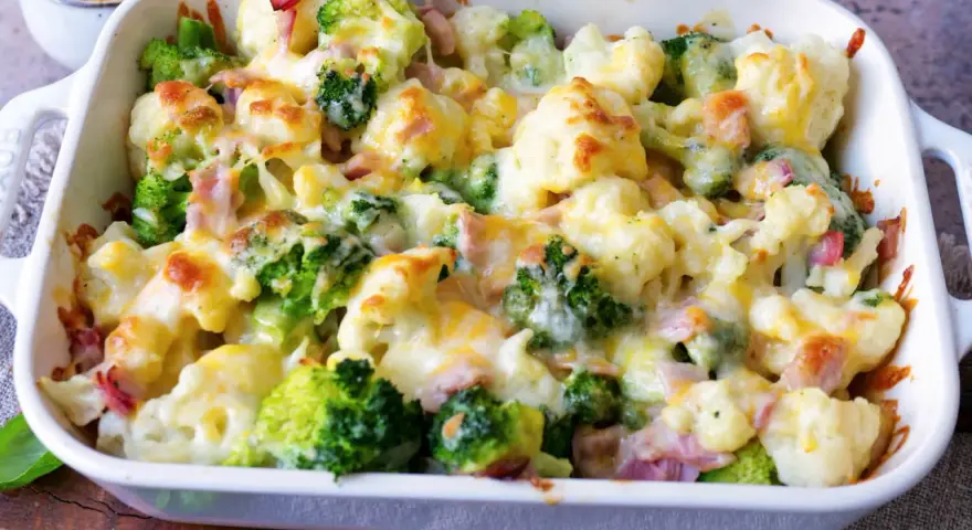Ein köstlicher Blumenkohlauflauf mit Brokkoli und Schinken, überbacken mit geschmolzenem Käse.