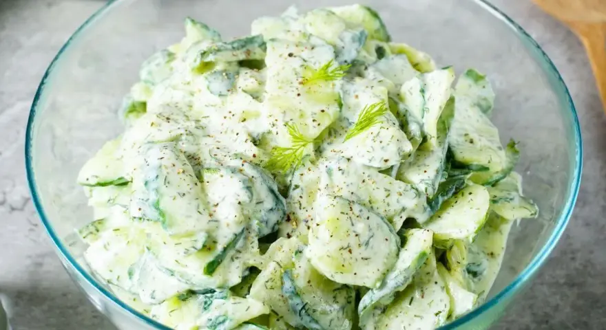 Frischer Gurkensalat mit cremigem Dressing und Dill, garniert mit Pfeffer. Ein leichter Genuss!