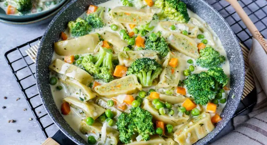 Herzhafte Maultaschen in cremiger Soße mit Brokkoli, Erbsen und Karotten. Ein leckeres Gericht, das Lust auf mehr Maultaschen Rezepte macht.