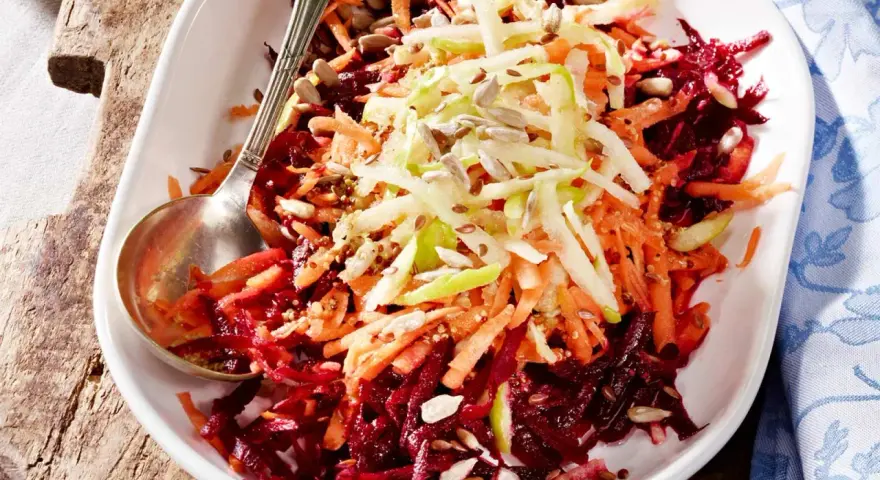 Bunter Rote Bete Salat mit geraspelten Karotten und Apfel, bestreut mit Sonnenblumenkernen und Leinsamen.