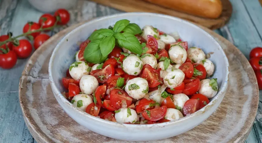 Tomate Mozzarella Salat mit frischem Basilikum und einem leichten Dressing. Perfekt als leichte Mahlzeit.