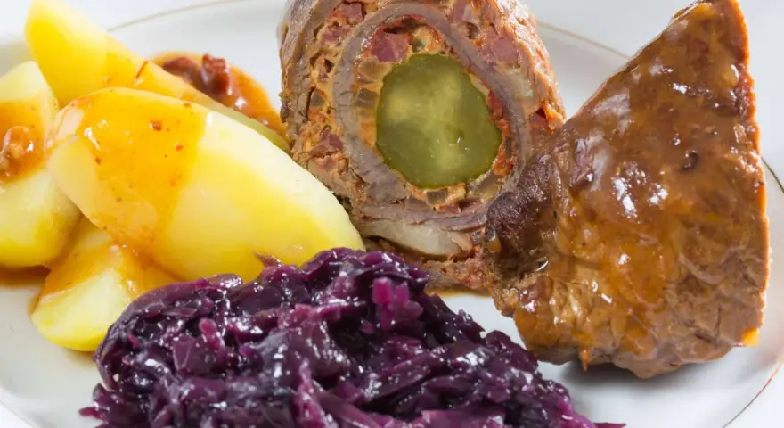 Rinderrouladen mit Rotkohl und Kartoffeln, ein deftiges Gericht, das nach Hausmannskost schmeckt.
