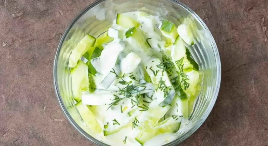 Erfrischender Gurkensalat mit Joghurt und Dill in einer Glasschüssel, bereit zum Genießen.