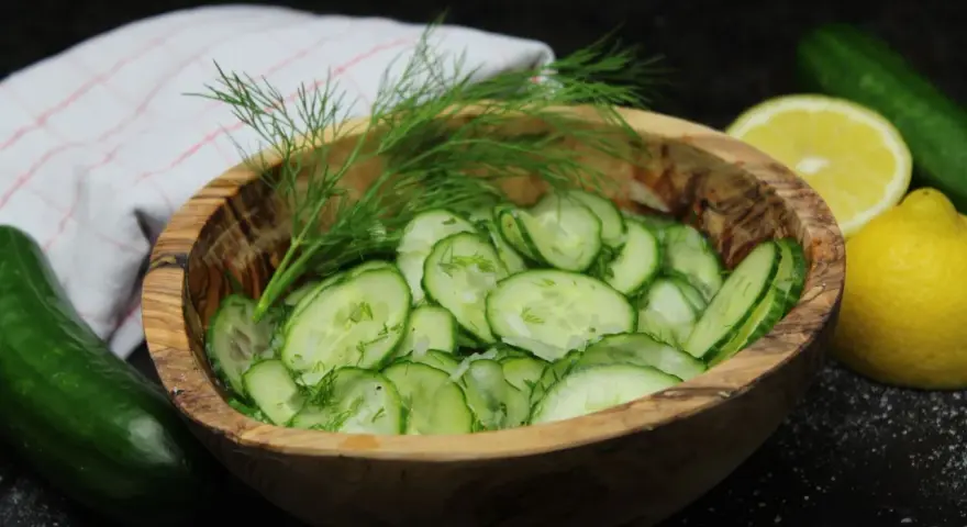 Frischer Gurkensalat im Holzschälchen, garniert mit Dill. Ein einfaches gurkensalat rezept für den Sommer.