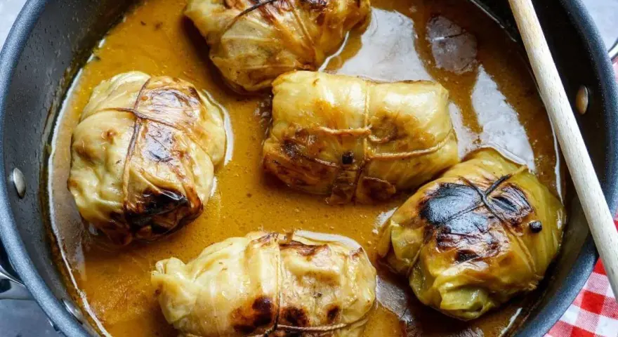 Fünf Kohlrouladen im Topf, bereit für ein köstliches Kohlrouladen Rezept.