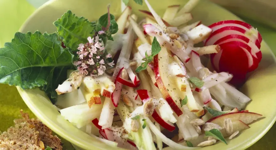 Frischer Kohlrabi Salat mit Apfel, Radieschen und Kräutern, garniert mit Sonnenblumenkernen. Ein leichter Genuss!