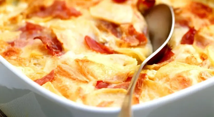 Schinken Sahne Auflauf ohne Vorkochen: Kartoffelscheiben mit Schinken und cremiger Sauce im Auflauf, bereit zum Servieren.